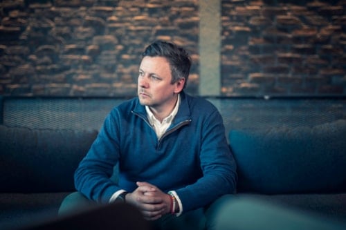 Mann som sitter på sofa med bekymret uttrykk